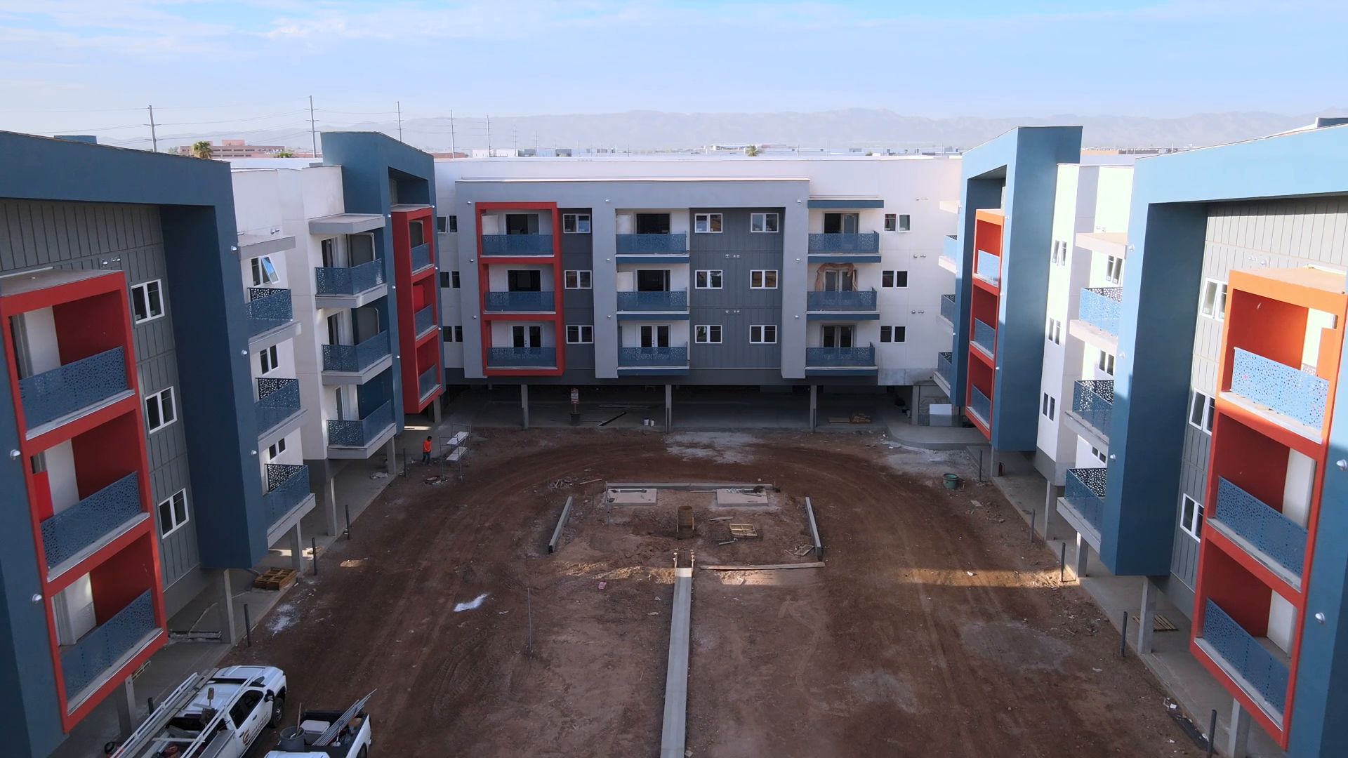 Sydney P. Osborn 2, a four-story apartment community with white, blue, and red accent walls around a central courtyard